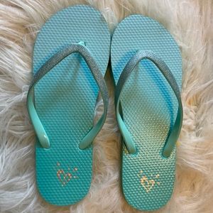 Flip flops that are blue with glitter and grips